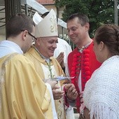 Na ręce bp. Piotra Gregera rodziny złożyły ofiarę na dzieła Caritas.