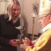 Aleksandra Golińska z Płocka odebrała statuetkę św. Michała Archanioła z rąk bp. Romana Marcinkowskiego.