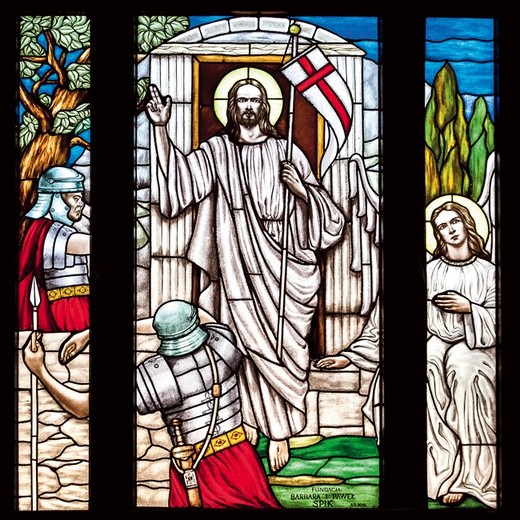 Witraż przedstawiający scenę Zmartwychwstania znajduje się nad chórem, ale wchodząc do kościoła, możemy zobaczyć jego odbicie wokół krzyża w prezbiterium.