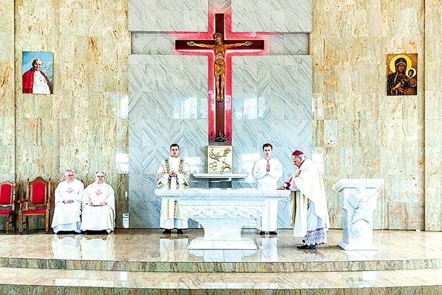 Biskup namaszcza ołtarz świętymi olejami.
