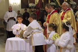 Ks. Henryk Oleś z pierwszokomunijnymi dziećmi wniósł relikwie bł. ks. Jerzego Popiełuszki, złożone później w ołtarzu.