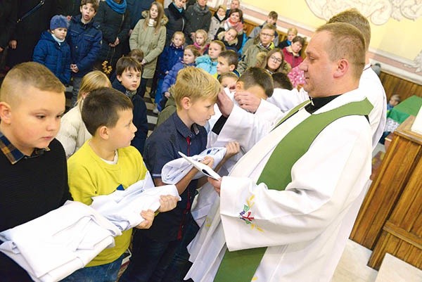 ◄	Obrzęd przyjęcia do grona ministrantów kończy nałożenie poświęconego stroju.