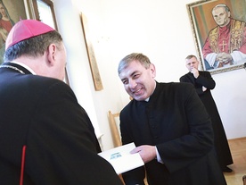 ▲	Ksiądz Janusz Kłęczek, prepozyt kapituły, odbiera nominację od  biskupa Andrzeja Jeża.