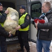 Dary wynoszą strażnicy miejscy. Z prawej ks. Robert Kowalski, szef radomskiej Caritas