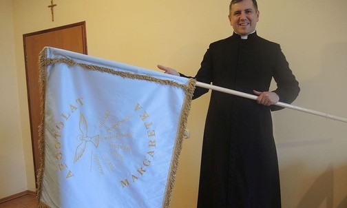 Ks. Krzysztof Rębisz prezentuje sztandar Apostolatu Margaretka