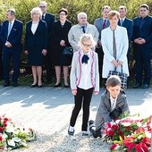 Uczniowie zabrzańskich szkół składają kwiaty przy tablicach upamiętniających ofiary zbrodni katyńskiej i katastrofy smoleńskiej. W tle przedstawiciele władz miasta.