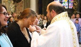 Magdalena całuje pobłogosławiony wcześniej krzyż misyjny.