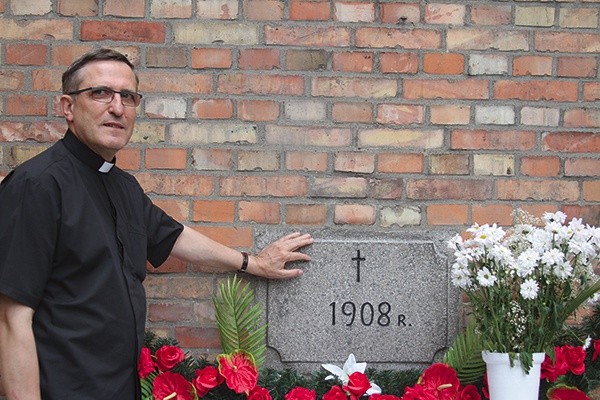 ▼	Ks. proboszcz Czesław Stolarczyk przy kamieniu węgielnym z wyrytą datą 1908 r. – to początek budowy domu Bożego.