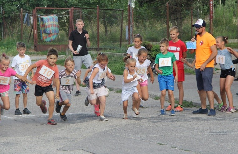 Mariusz Mędra daje sygnał "start" młodym zawodnikom biegu ulicznego