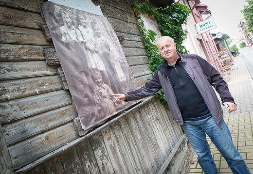 Krzysztof Skibiński przy swojej fotografii z dzieciństwa na budynku przy ul. Krótkiej.