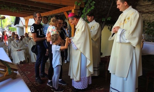 Biskup Roman Pindel przyjmuje pielgrzymią legitymację z rąk rodziny Kantyków z Kamesznicy.