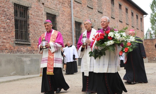 Od prawej: abp Marek Jędraszewski, abp Ludwig Schick i bp Roman Pindel przed Ścianą Śmierci na dziedzińcu bloku 11