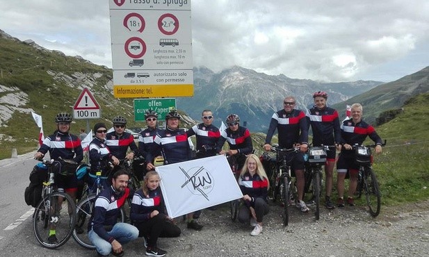 Rowerzyści i samochodowe ekipy techniczne w Alpach