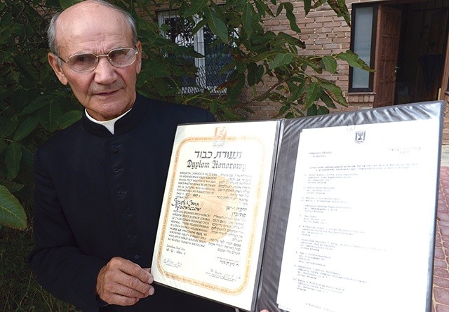 Ksiądz Kosowicz pokazuje dyplom Instytutu  Yad Vashem.