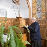 Ksiądz proboszcz Tadeusz Żdanuk prezentuje mechanizm pokrywy chrzcielnicy.