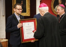 Redaktor naczelny odbierający nagrodę.