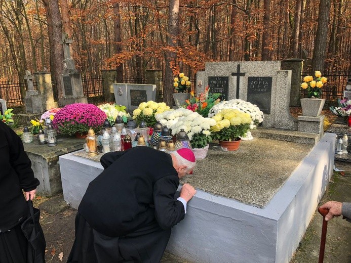 Biskup Ignacy całuje grób swoich rodziców.