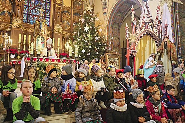 ▲	Świąteczna sceneria ciechanowskiej fary ze Świętą Rodziną i dziećmi słuchającymi kazania bp. Piotra.
