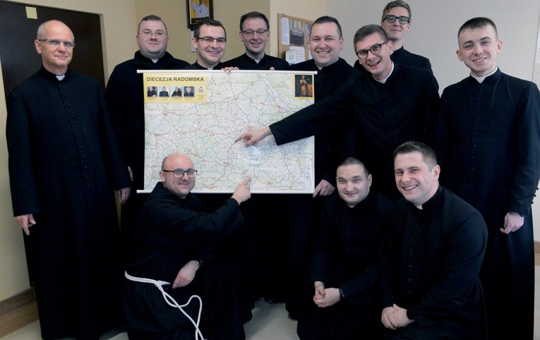 Radomscy diakoni z rektorem ks. Jarosławem Wojtkunem (z lewej) przed mapą diecezji