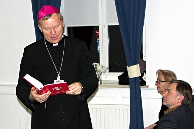 Biskup Piotr pokazuje „Modlitewnik Zakonu Maltańskiego”. Jednym z jego redaktorów jest R. Wiraszka.