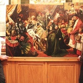 ▲	Ksiądz Andrzej Milewski i Szymon Zaremba, konserwator dzieł sztuki, prezentują odzyskany obraz „Nadanie herbu Kapitule Katedralnej Płockiej”.