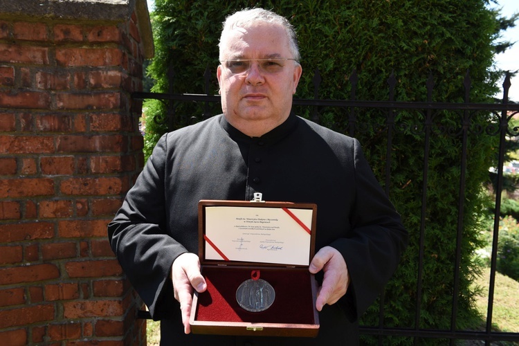 Ks. proboszcz Piotr Lisowski z Medalem Polonia Minor.