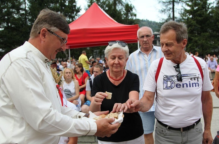 Wójt Brennej Jerzy Pilch częstuje uczestników dożynek chlebem z tegorocznej mąki.