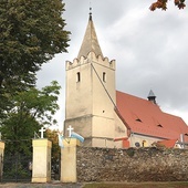 ▲	Kościół parafialny otacza mur z kamienia polnego, odłamków skalnych i cegły.