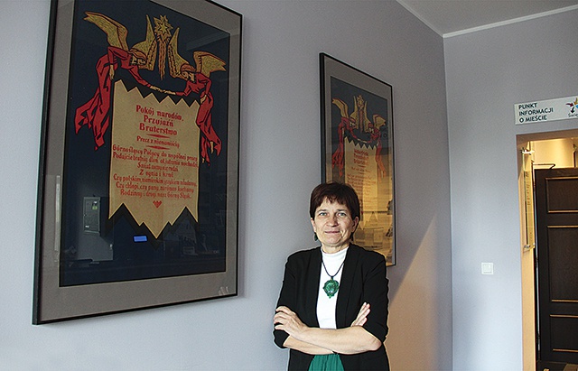 	Halina Bieda, dyrektor muzeum. Za nią jej ulubiony eksponat – plakat wydany w językach polskim i niemieckim, mówiący o wspólnej miłości do Górnego Śląska.