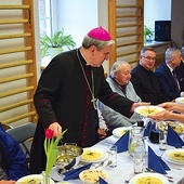 Biskup sandomierski podczas obiadu z osobami potrzebującymi.
