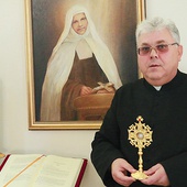 Ks. proboszcz Robert Brzozowski pokazuje relikwiarz  i obraz Miriam umieszczony w kościele.