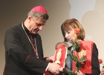 Bp Roman Pindel wręczył nagrodzonej Urszuli Kraus statuetkę: miniaturę figury Matki Bożej wykonaną przez więźnia w Auschwitz.