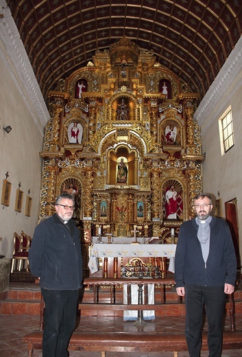 Ks. Łukasik (z lewej) i ks. Tworzydło (z prawej)  na tle odnowionego zabytkowego ołtarza.