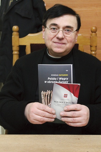 Ks. Maciej Józefowicz z książkami o historii Polaków i Węgrów.
