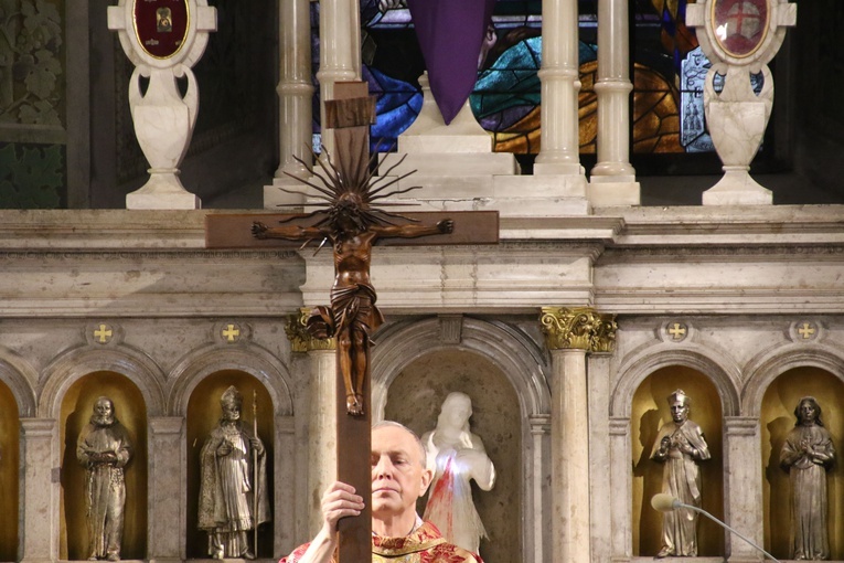Biskup Libera ukazuje krzyż do adoracji - to centralny moment liturgii Wielkiego Piątku.