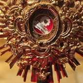 Fragmenty kości św. Andrzeja Boboli otoczone są drobnymi kryształkami, owinięte w jedwab i umieszczone w szklanej kapsule relikwiarza.