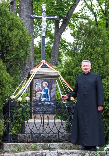 Ks. Wojciech przy krzyżu, gdzie umieszczono wizerunek świętej.