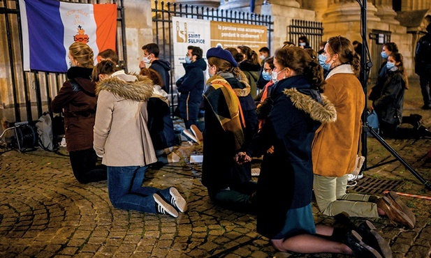 Katolicy modlący się przed zamkniętym z powodu epidemicznych obostrzeń kościołem pw. św. Sulpicjusza w Paryżu.