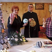 	Panie Genowefa (z prawej) i Marianna z ks. Gabrielem Marciniakiem prezentują świąteczne ozdoby.