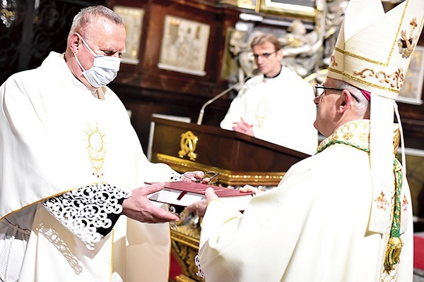 Biskup otrzymaną księgę intencji i podziękowań przekazał proboszczowi.