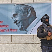 Plakat zapowiadający wizytę papieża, zawieszony na murze katedry w Bagdadzie.
