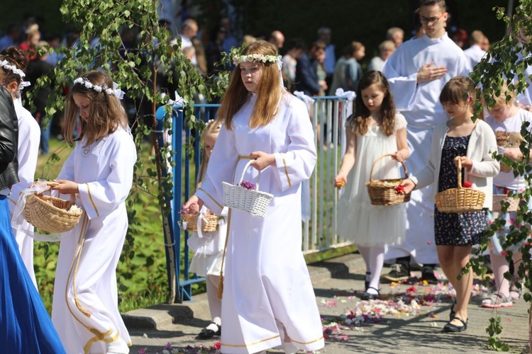 Dziewczynki, które kilka dni temu po raz pierwszy przystąpiły do Komunii Świętej, sypały kwiaty przed kapłanem niosącym monstrancję.
