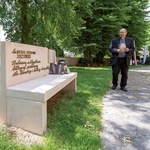 Proboszcz ks. Ryszard Piwowarczyk obok ławeczki ku czci zasłużonego dla miasta ks. Michała Juszyńskiego.