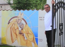 Ks. Maciej Jastrzębski, proboszcz parafii św. Stanisława BM przy muralu z Prymasem Tysiąclecia.