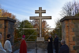 Krzyż morowy został zamontowany przy murze okalającym klasztor.