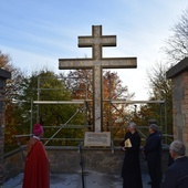 Krzyż morowy został zamontowany przy murze okalającym klasztor.