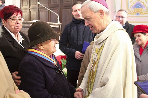 Biskup płocki w rozmowie z uhonorowaną Orderem św. Zygmunta Martą Dąbrowską i innymi członkami wspólnoty.