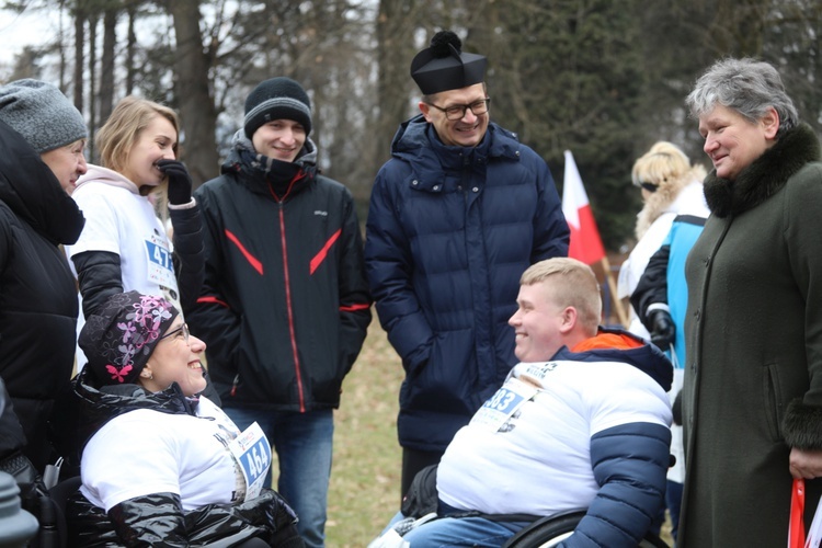 Prezes Jadwiga Klimonda i ks. Krzysztof Ciurla z biegaczami na wózkach: Magdaleną Wójcik i Sebastianem Balasem.