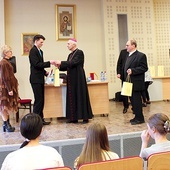 Biskup Andrzej Iwanecki wręcza nagrody najlepszym uczestnikom konkursu.