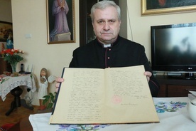Ks. Leszek Niedźwiedź pokazuje protokół wizytacji spisany przez bp Stefana Wyszyńskiego.